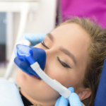 Photo of dental patient with mask on her face receiving nitrous oxide