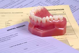 A Denture sitting on top of paper forms
