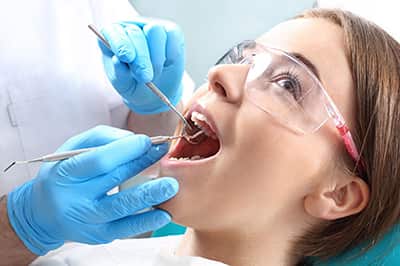 A woman receiving a dental check up after her teeth cleaning
