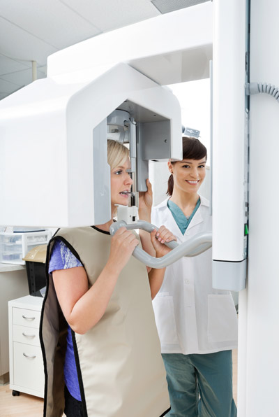 Photo of a patient in imaging machine to have panoramic x-rays of her jaw