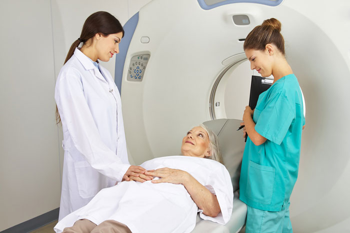 Doctor and assistant with patient and MRI machine